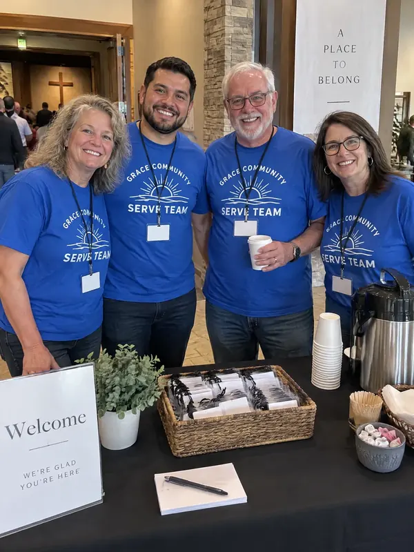 Four church volunteers in blue Grace Community Serve Team shirts